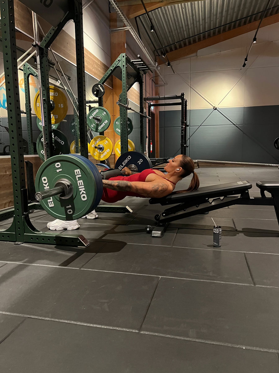 Tränaren poserar med sitt självförtroende på gymmet.